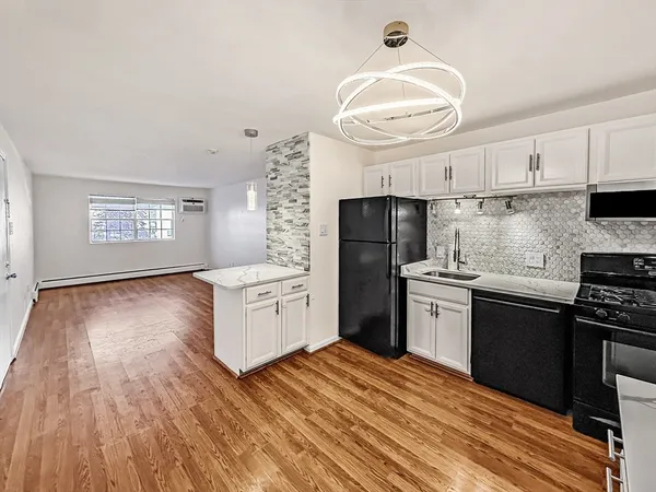 a kitchen with granite countertop a refrigerator stove top oven and sink
