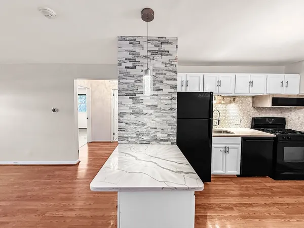 a kitchen with granite countertop a refrigerator stove and oven