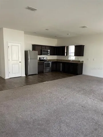 a living room with furniture and a kitchen