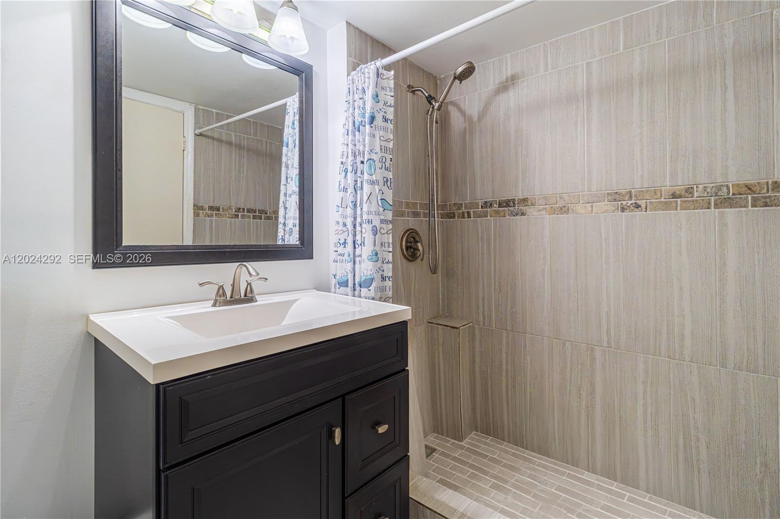 9780 Marina Boulevard, Unit 424 Boca Raton, FL 33428 - Photo 22 of 32 a bathroom with a sink and a mirror