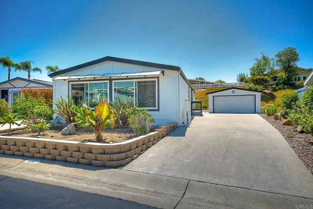 a front view of a house with a yard and potted plants