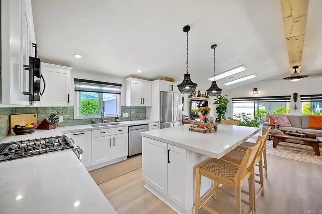 a kitchen with a sink a stove and chairs