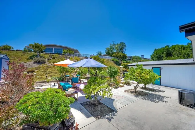 a view of a patio with furniture and a garden