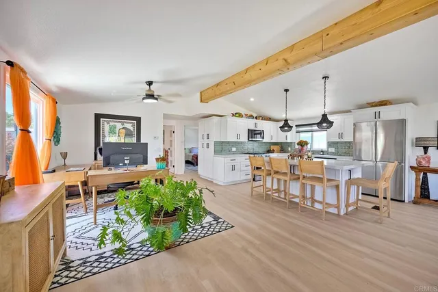 a living room with lots of furniture and kitchen view