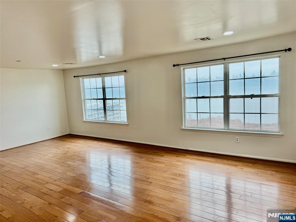 34 Bergen Ridge Road, Unit 2 North Bergen, NJ 07047 - Photo 7 of 41 an empty room with wooden floor and windows