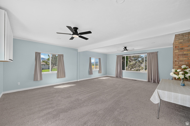 4468 North Droubay Road Tooele, UT 84074 - Photo 14 of 60 Spacious room featuring neutral carpeting, light-colored walls, and a visible brick accent wall