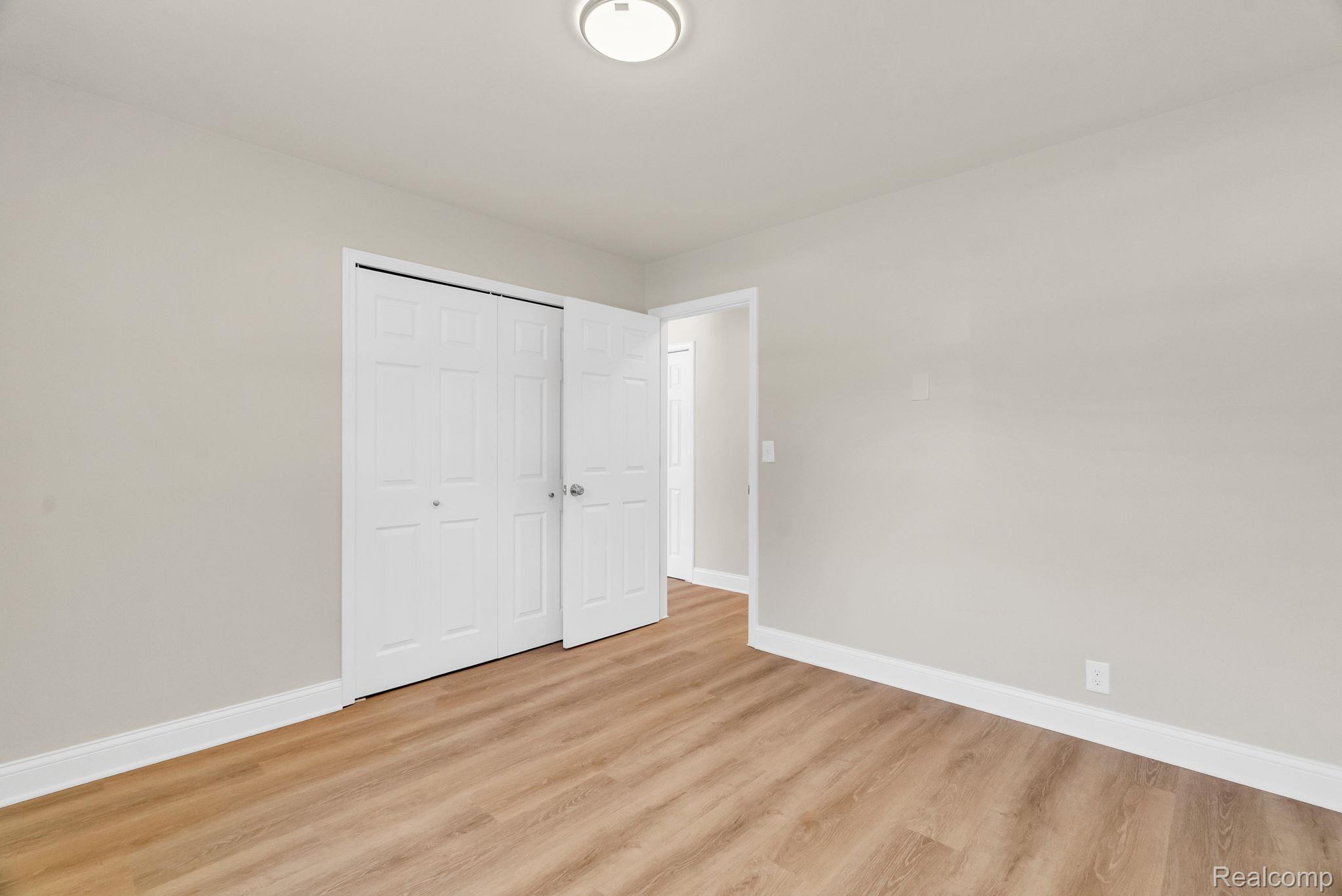 4046 State Road Fort Gratiot, MI 48059 - Photo 25 of 38 Room featuring wood-finish flooring, light neutral wall paint, and white trim