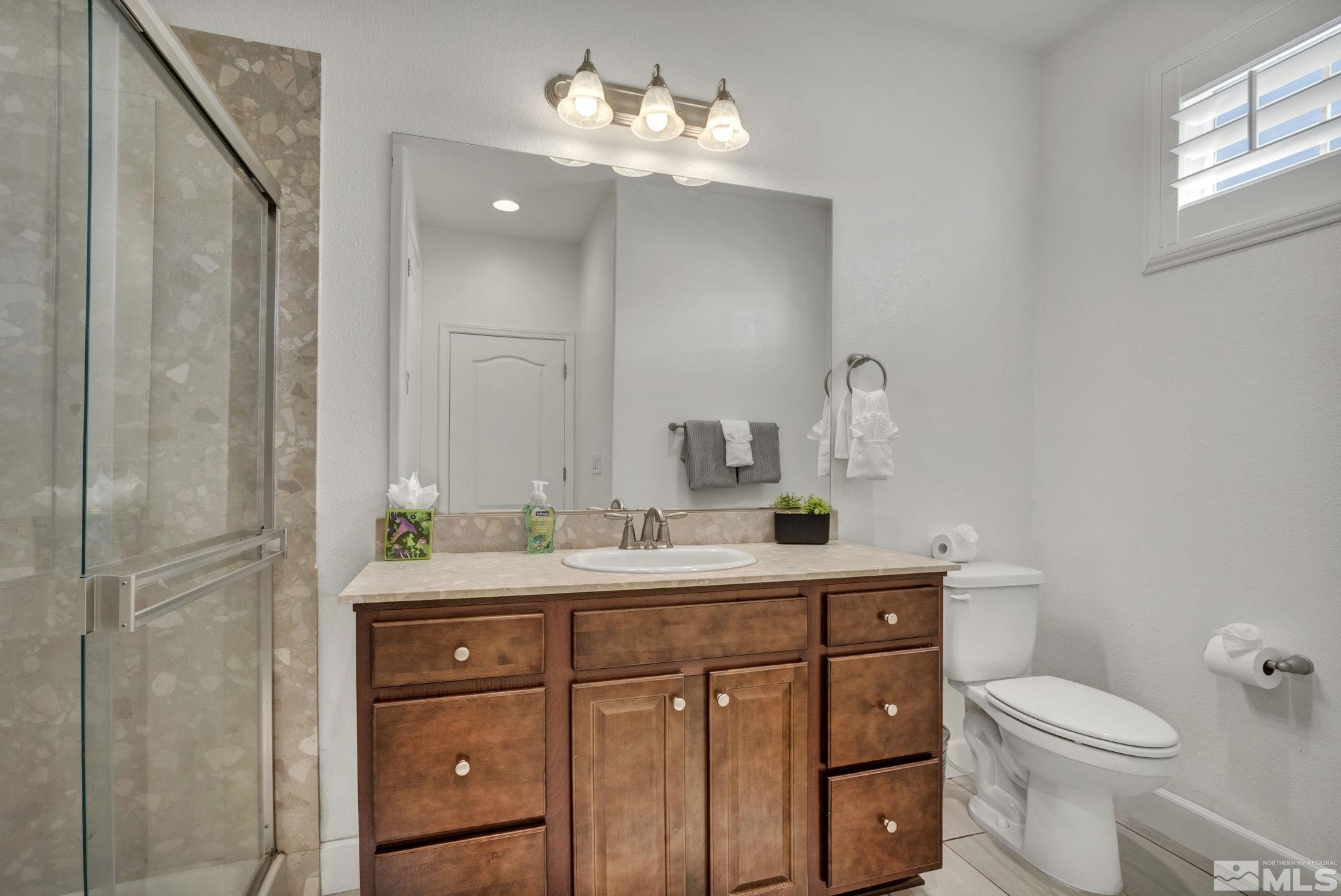 10345 Rollins Drive Reno, NV 89521 - Photo 26 of 39 a bathroom with a toilet a sink and mirror