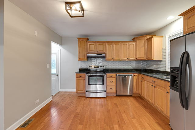 1211 Telegraph Road Lake Forest, IL 60045 - Photo 7 of 21 a kitchen with granite countertop wooden floors stainless steel appliances a sink and a window