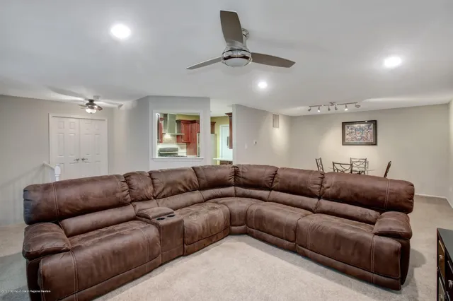 a living room with furniture and a ceiling fan