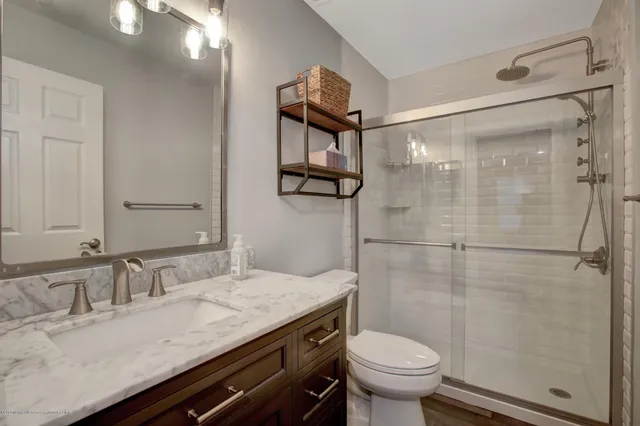 a bathroom with a granite countertop sink toilet and shower