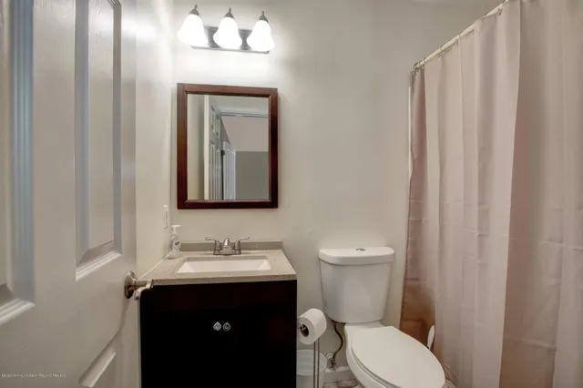 a bathroom with a toilet a sink and mirror