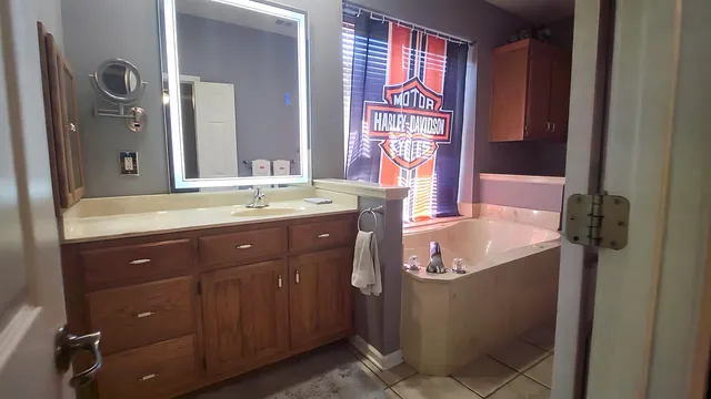 a bathroom with a granite countertop sink and a mirror