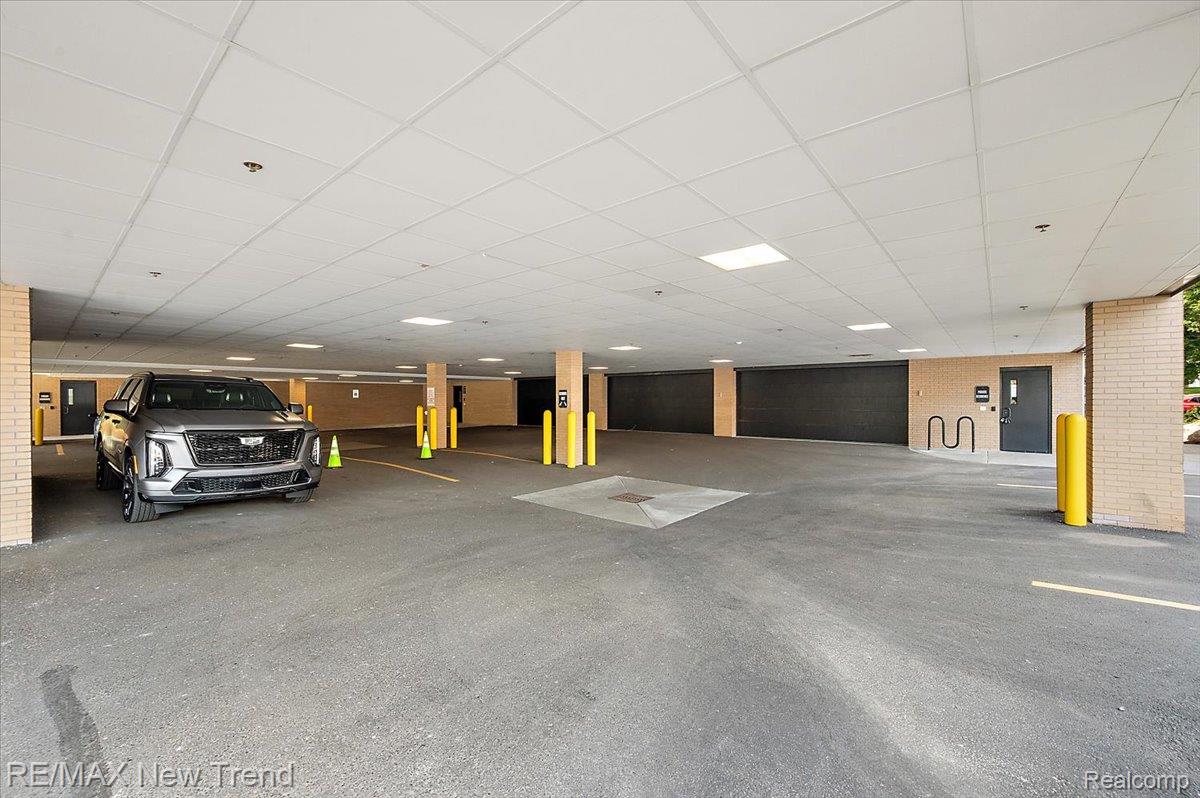 804 North Main Street, Unit 2H Rochester, MI 48307 - Photo 41 of 52 Covered parking area with asphalt surfacing, brick-clad columns, and recessed lighting