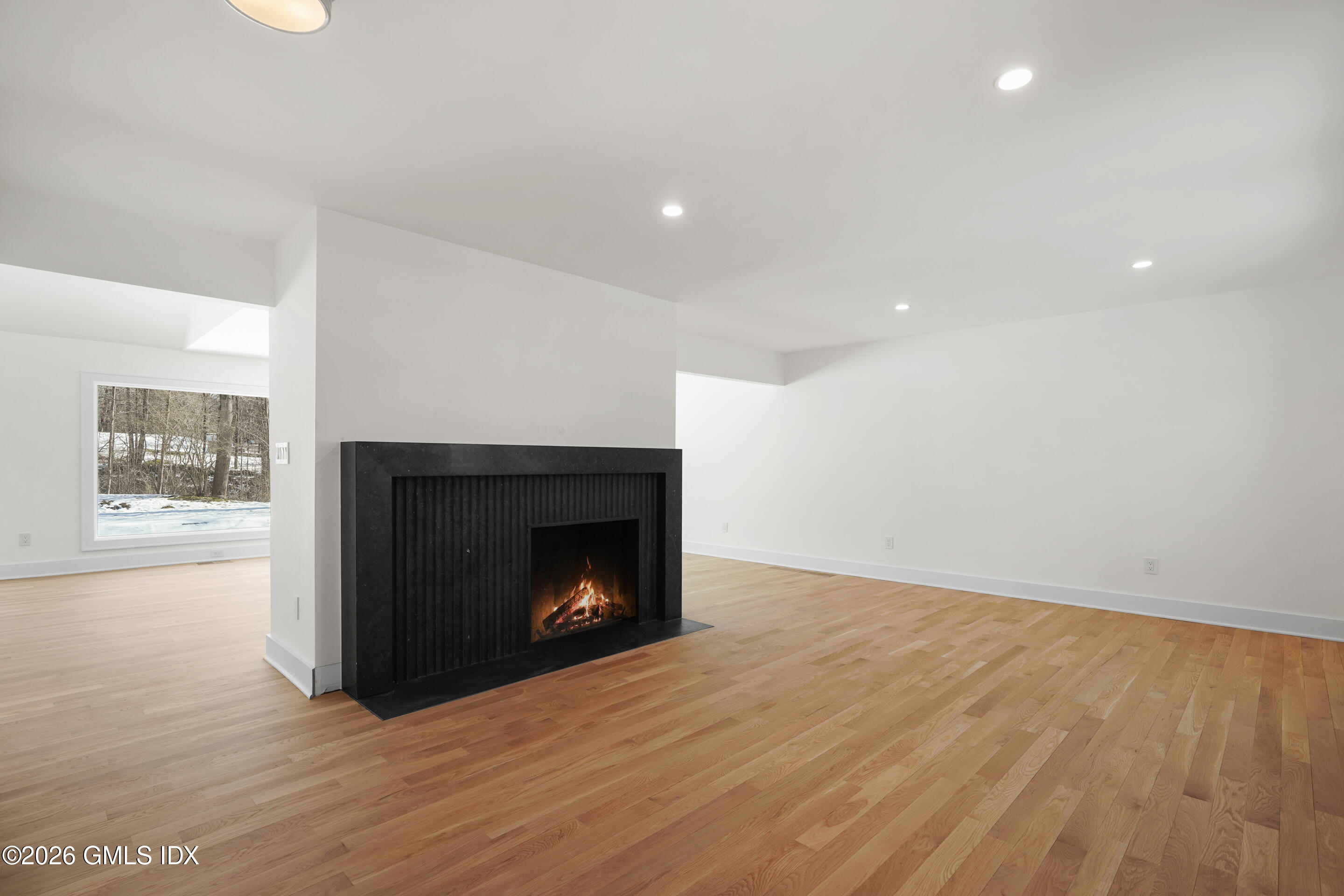 403 Stanwich Road Greenwich, CT 06830 - Photo 12 of 31 a view of an empty room with wooden floor fireplace and a window