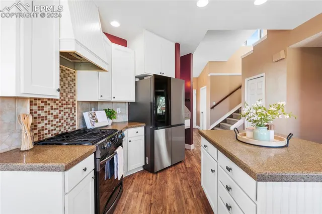 a kitchen with granite countertop white cabinets and white appliances