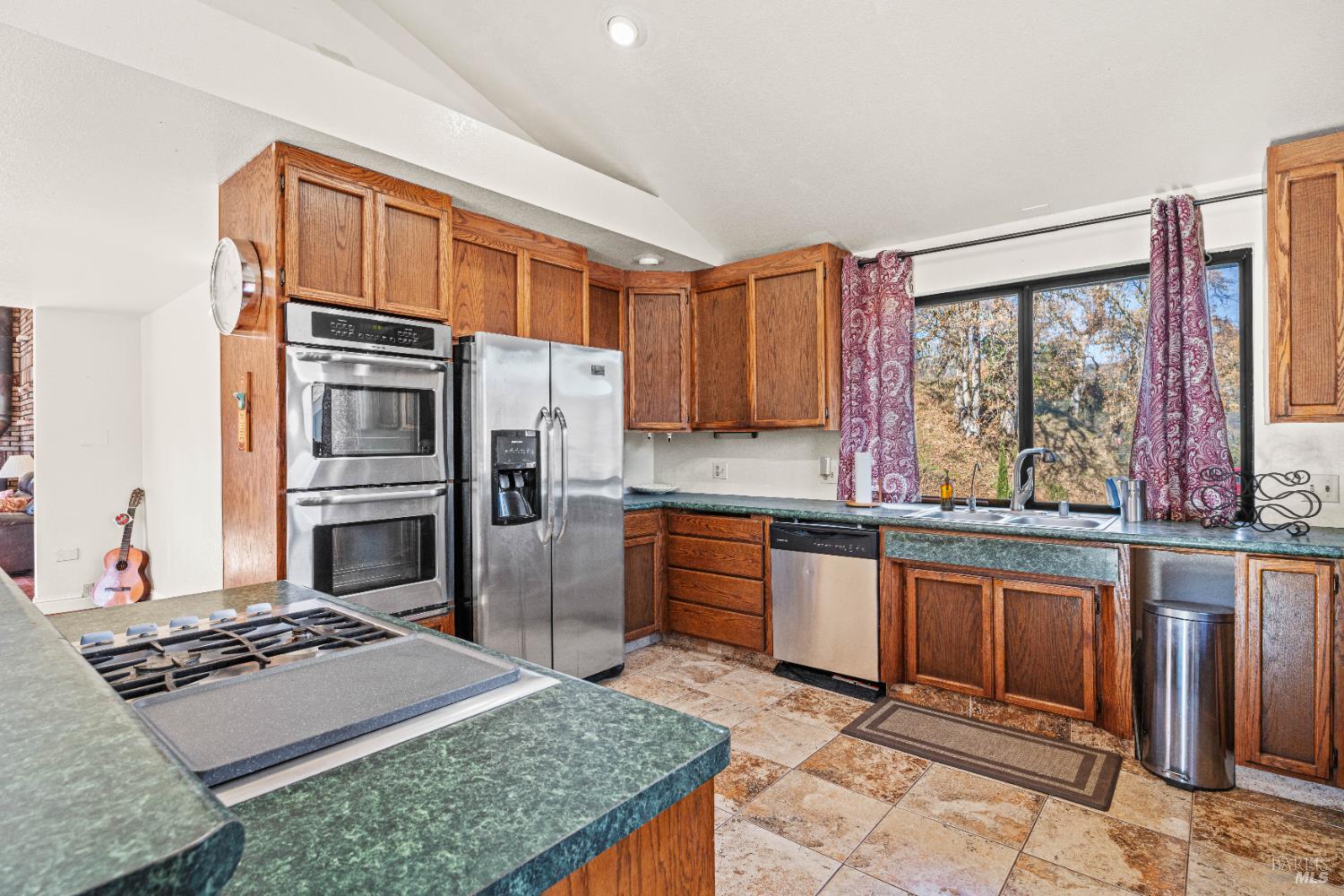 6620 Robinson Creek Road Ukiah, CA 95482 - Photo 35 of 47 a kitchen with stainless steel appliances granite countertop a stove top oven a sink refrigerator and cabinets