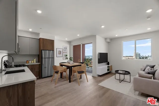 a living room with furniture a flat screen tv and a large window