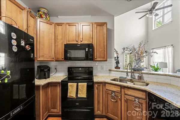 a kitchen with stainless steel appliances a sink a stove cabinets and a window