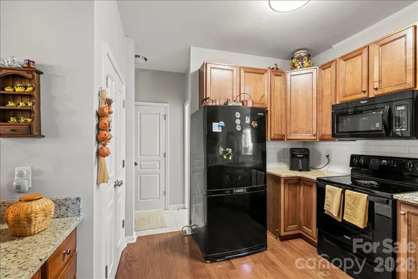 a kitchen with granite countertop a refrigerator stove and microwave