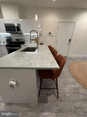 a kitchen with stainless steel appliances a refrigerator a stove a sink and dishwasher