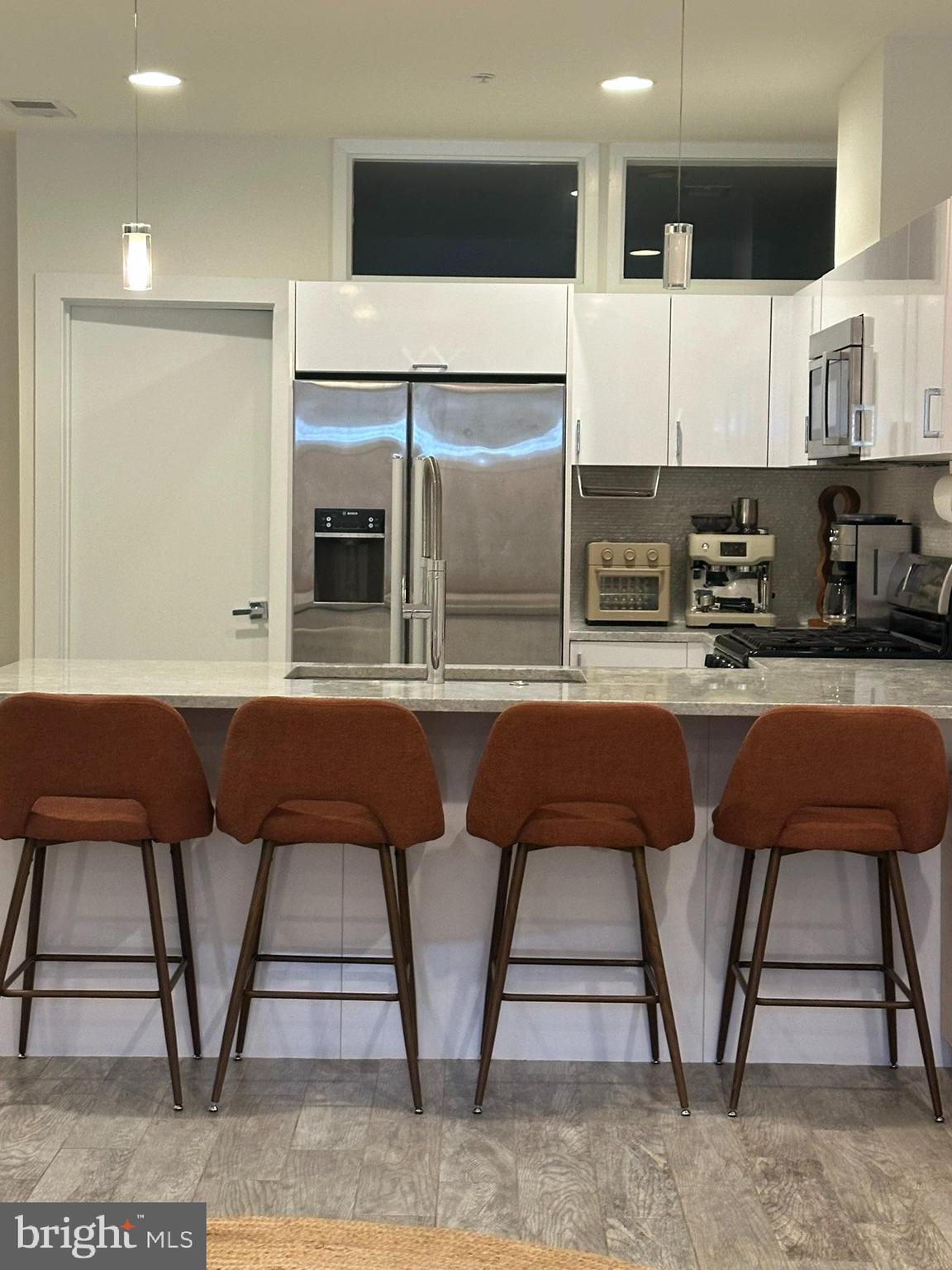 1837 Kalorama Road Northwest, Unit B Washington, DC 20009 - Photo 28 of 45 a kitchen with stainless steel appliances kitchen island granite countertop a refrigerator and microwave