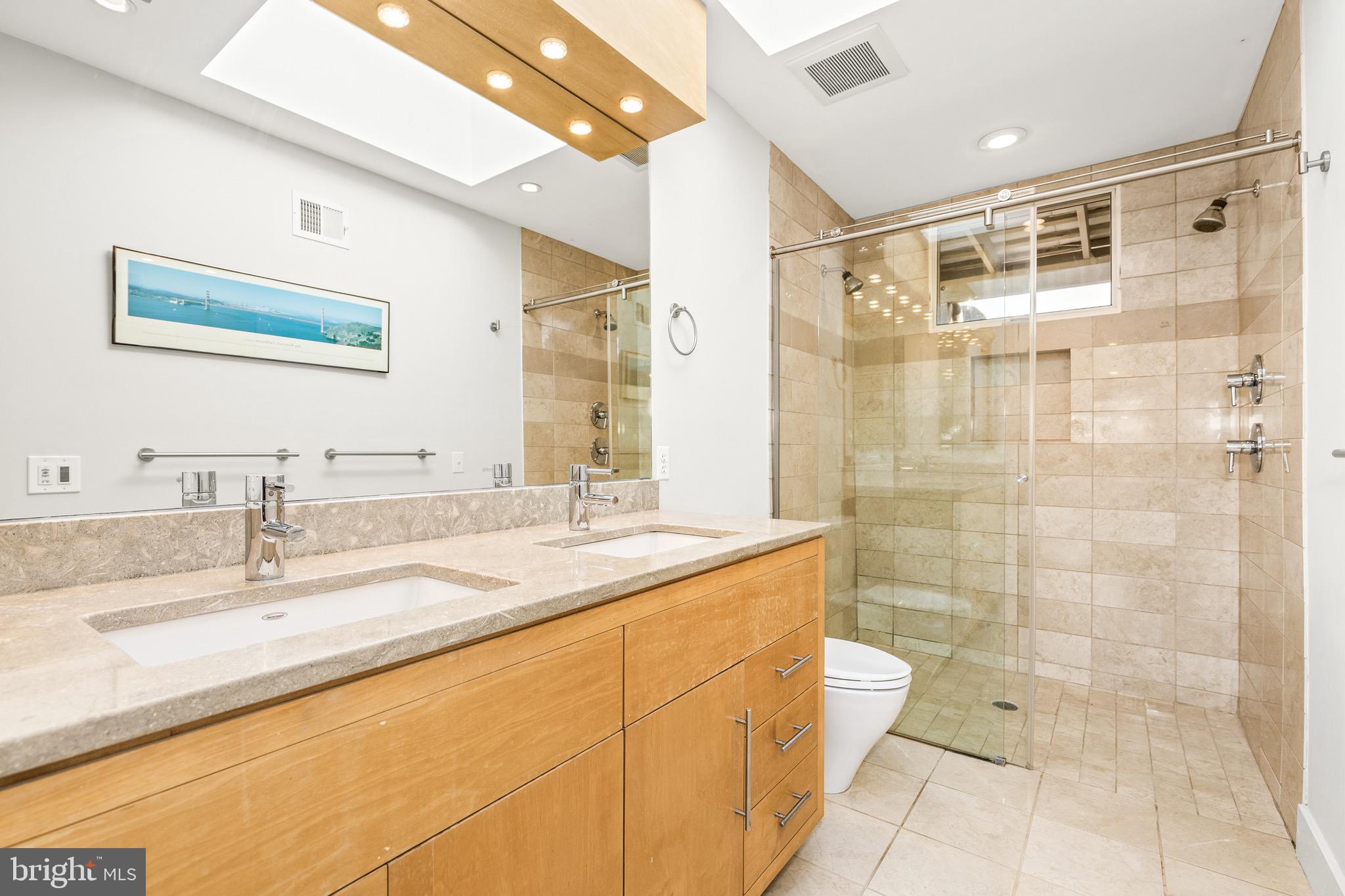 1716 Irving Street Northwest Washington, DC 20010 - Photo 28 of 43 a bathroom with a granite countertop sink a toilet a mirror and shower