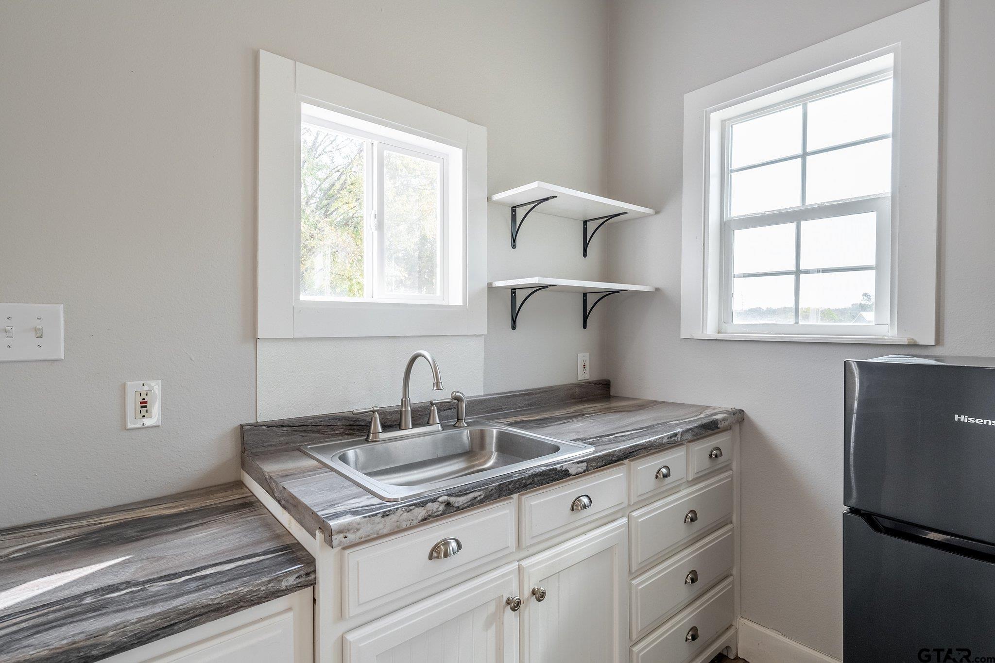 a bathroom with a granite countertop sink a mirror and a window