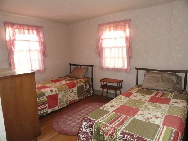61 Lawrence Road Dennis Port, MA 02639 - Photo 8 of 14 a bedroom with a bed and wooden floor