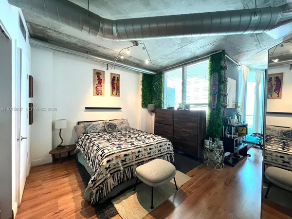 a bedroom with a bed and wooden floor