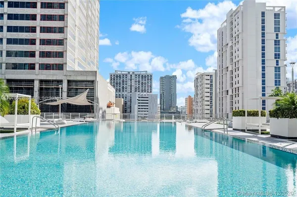 a house view with swimming pool outdoor seating and a lots of buildings