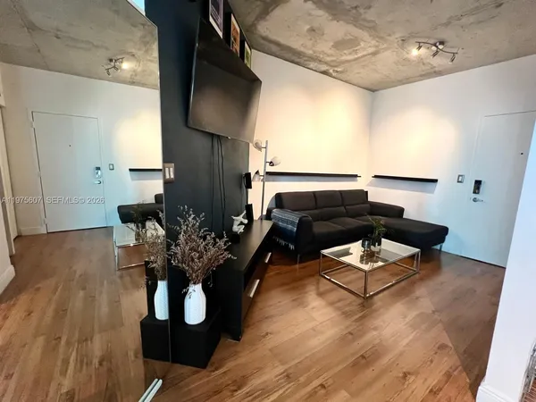 a living room with furniture and wooden floor