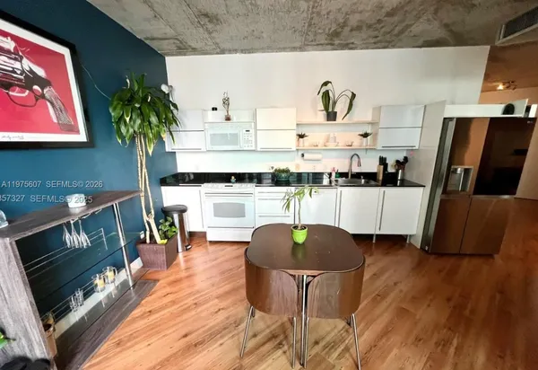 a kitchen with stainless steel appliances a stove a chimney a sink and wooden floor