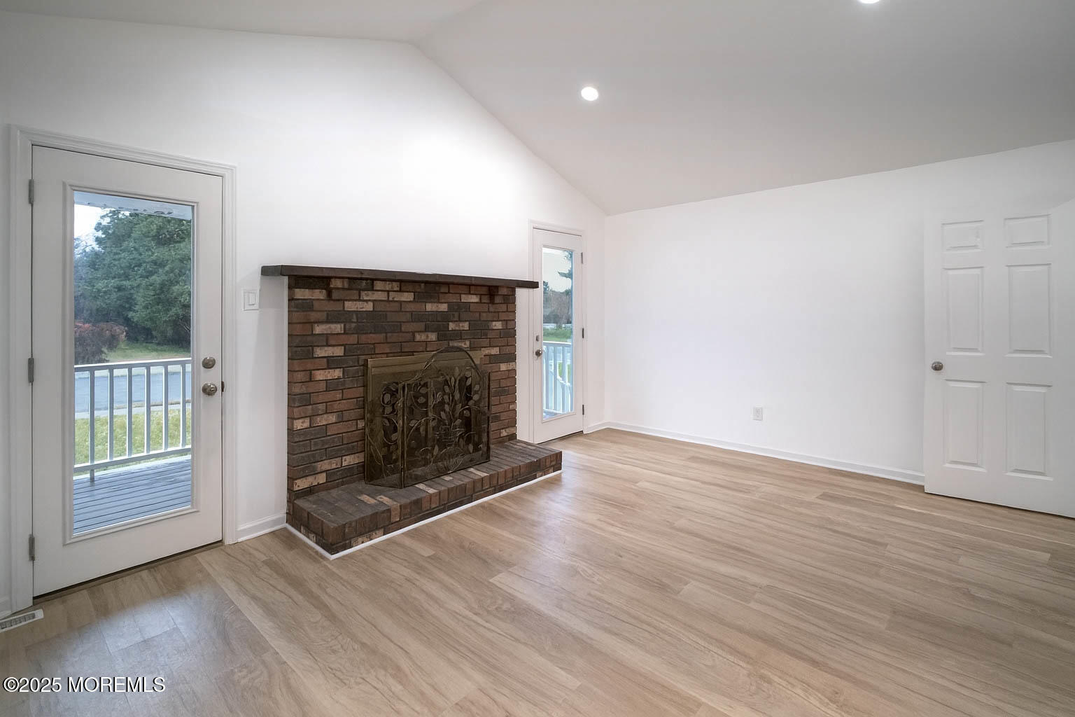 125 Shore Road Marmora, NJ 08223 - Photo 6 of 27 an empty room with wooden floor fireplace and windows