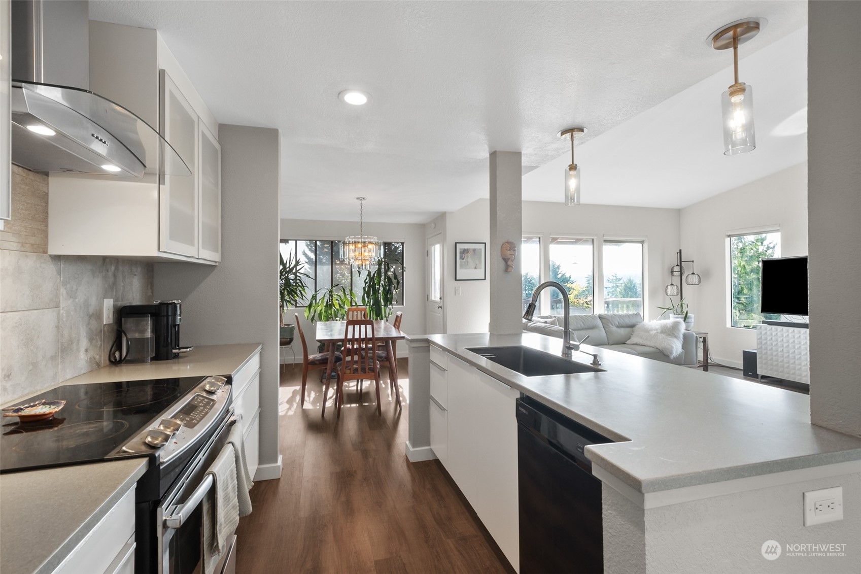 1501 Eagle Ridge Drive South, Unit G5 Renton, WA 98055 - Photo 14 of 23 a kitchen with sink stove and white cabinets with wooden floor