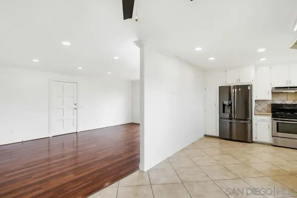 a view of kitchen with stainless steel appliances a refrigerator and wooden floor