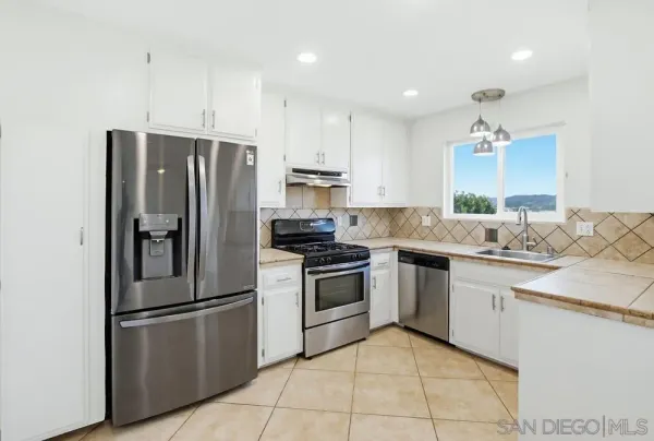 a kitchen with stainless steel appliances granite countertop a refrigerator stove and sink