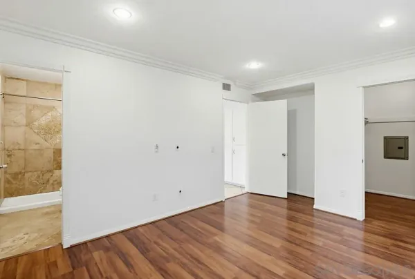 a view of empty room with wooden floor