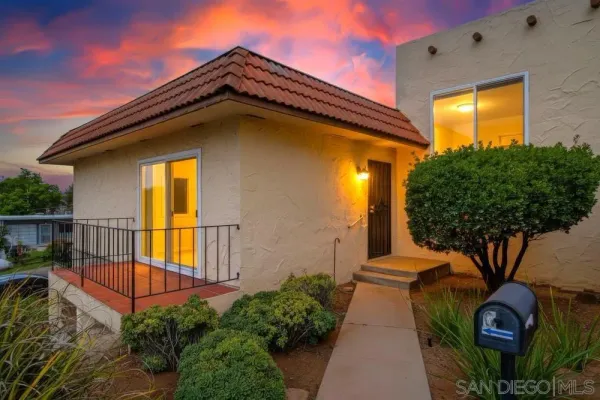 a front view of a house with plants