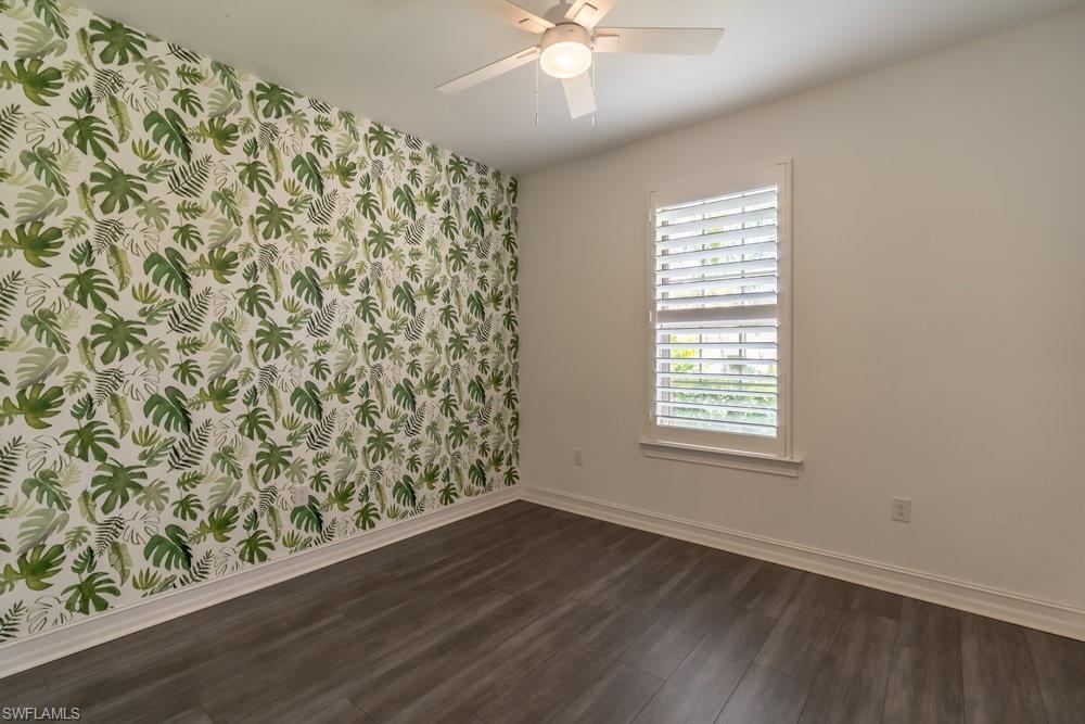 16374 Barclay Court Naples, FL 34110 - Photo 14 of 32 an empty room with wooden floor and windows