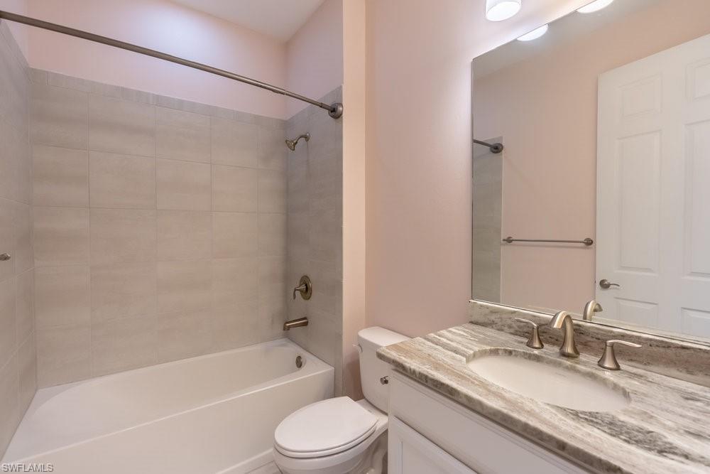 16374 Barclay Court Naples, FL 34110 - Photo 15 of 32 a bathroom with a granite countertop bathtub shower sink vanity mirror and toilet