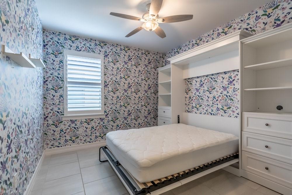 16374 Barclay Court Naples, FL 34110 - Photo 17 of 32 a bedroom with a bed and a chandelier