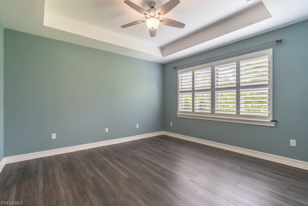 16374 Barclay Court Naples, FL 34110 - Photo 19 of 32 wooden floor in an empty room with a window