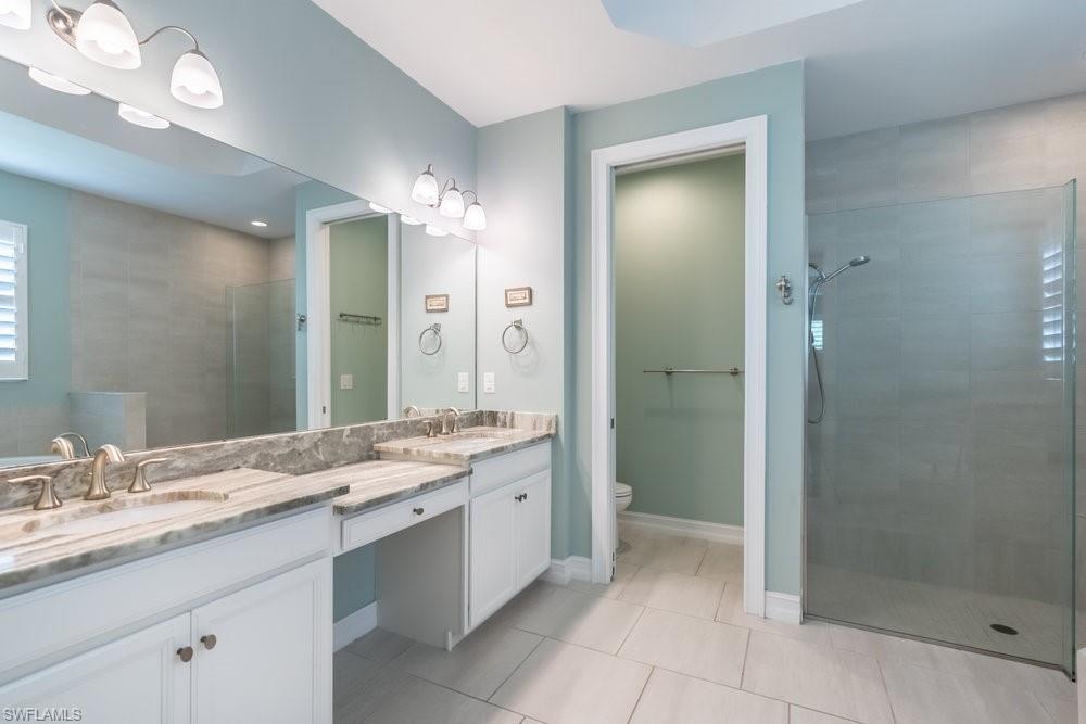16374 Barclay Court Naples, FL 34110 - Photo 21 of 32 a bathroom with a granite countertop sink shower and a mirror