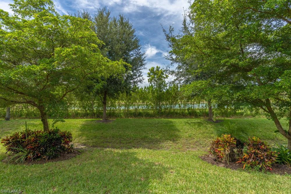 16374 Barclay Court Naples, FL 34110 - Photo 27 of 32 a backyard of a house with lots of green space and garden