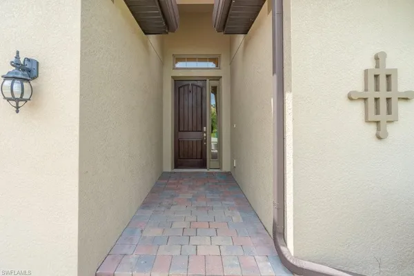 a view of a hallway with wooden floor and a bathroom