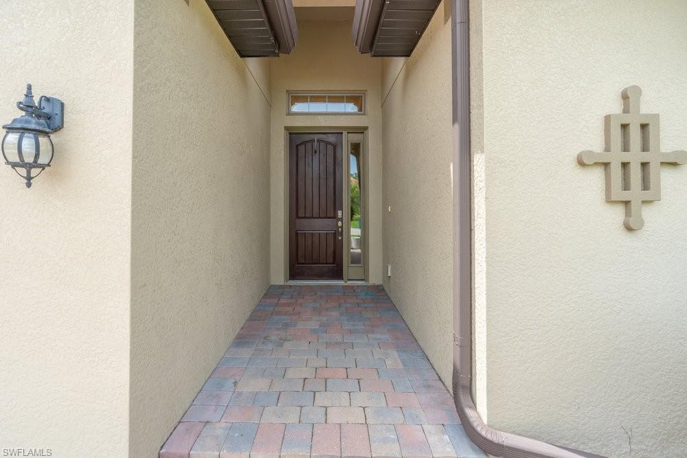 16374 Barclay Court Naples, FL 34110 - Photo 3 of 32 a view of a hallway with wooden floor and a bathroom