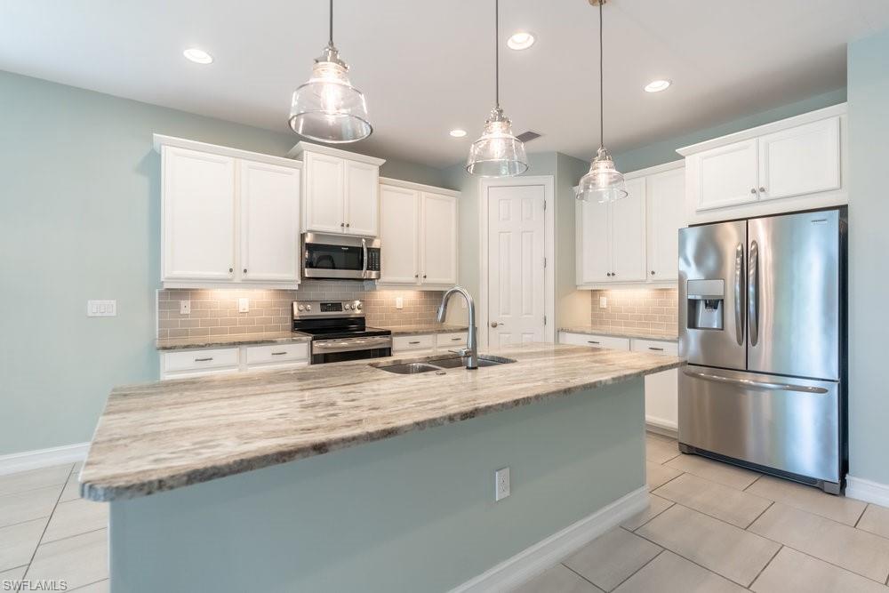 16374 Barclay Court Naples, FL 34110 - Photo 9 of 32 a kitchen with stainless steel appliances granite countertop a refrigerator a sink and a stove