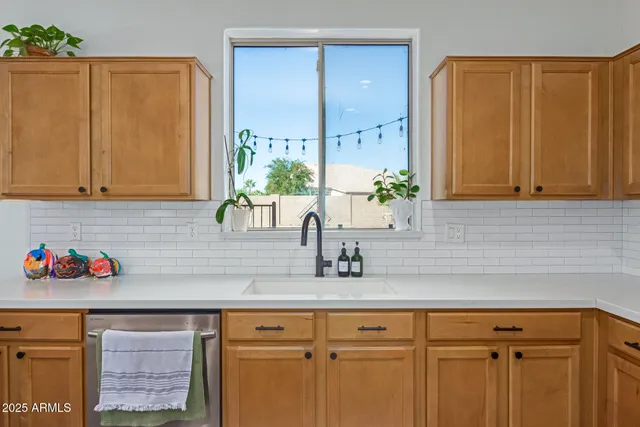 a kitchen with stainless steel appliances granite countertop a sink and cabinets with wooden floor