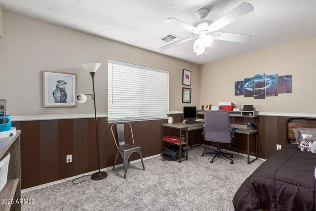 a view of a workspace with furniture and a window